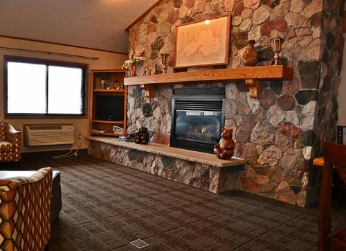 a living room with a large stone fireplace at AmericInn by Wyndham Calumet in Calumet