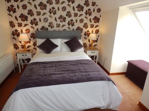 a bedroom with a large bed and two tables with lamps at Meadowfield in Ballyvaughan
