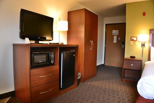 a hotel room with a television on top of a cabinet at AmericInn by Wyndham Calumet in Calumet