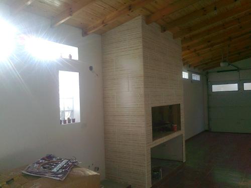 sala de estar con pared de ladrillo y TV en La casa de Silvia en Puerto Madryn