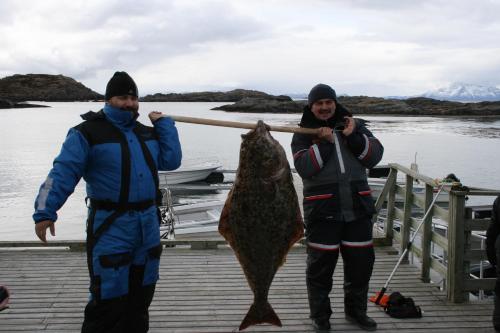 two people holding a fish on a dock at Offersøy Feriesenter in Offersøy