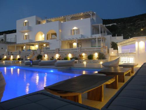 a villa with a swimming pool at night at Anna Platanou Suites in Agia Irini Paros