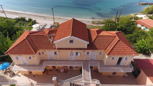 an aerial view of a large house with the beach at Rosa's Beach Studios in Lourdhata