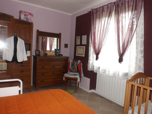 ApecchioにあるVilla Glicineのベッドルーム1室(ベッド1台、ドレッサー、窓付)