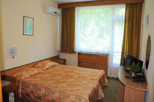 a hotel room with a bed and a television at Neptune Hotel in Saints Constantine and Helena