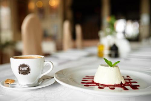a cup of coffee and a dessert on a table at Hotel Polski in Mielec