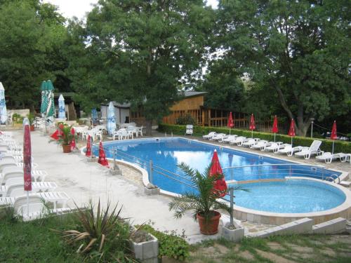 a swimming pool with chairs and umbrellas around it at Neptune Hotel in Saints Constantine and Helena