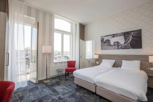 um quarto com uma cama branca e uma cadeira vermelha em Fletcher Hotel-Restaurant Middelburg em Middelburg