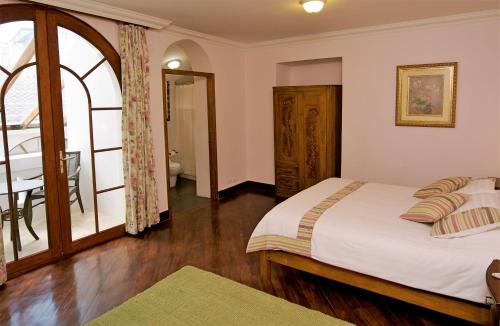 a bedroom with a bed and a table and a window at Boutique Hotel Casa Foch in Quito