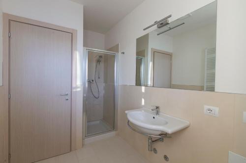 een witte badkamer met een wastafel en een douche bij Residenza Riva Azzurra in Rimini