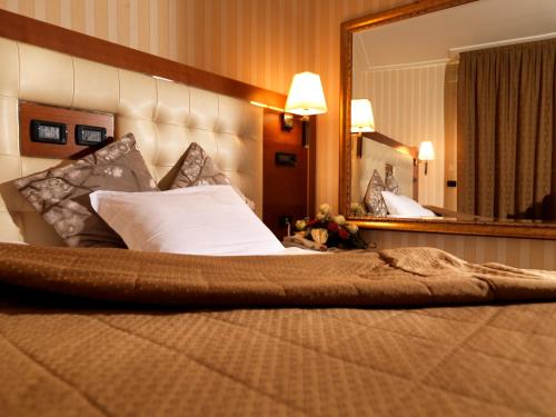 a bed in a hotel room with a large mirror at Hotel Ariston in Campodarsego