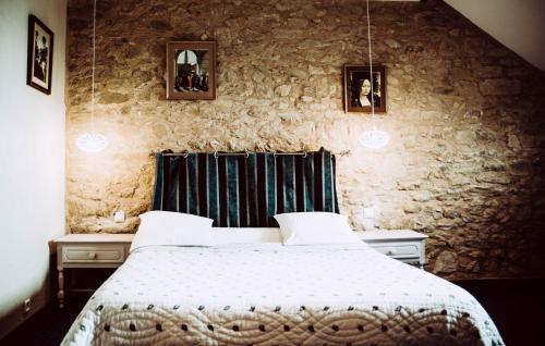 a bedroom with a bed and a stone wall at Domaine de Vareilles in Vareilles