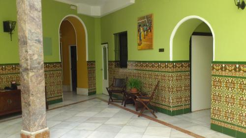 a room with green walls and a table and chairs at Al Andalus Jerez in Jerez de la Frontera