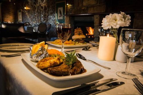 a table with a plate of food and glasses of wine at First Group Qwantani in Harrismith
