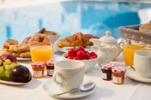 - une table avec des aliments pour le petit-déjeuner, des boissons et des viennoiseries dans l'établissement Anna Platanou Suites, à Agia Irini Paros