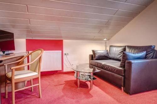 ein Wohnzimmer mit einem Sofa und einem Tisch in der Unterkunft Cafe Hoyer Pension und Appartements in Rödigsdorf