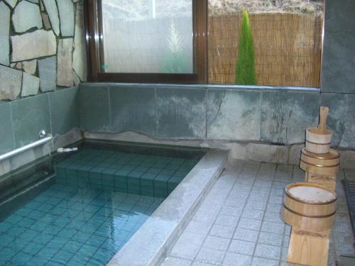 a bathroom with a tub with a toilet in it at Ashita no Mori in Hongu