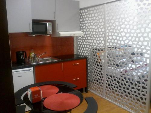 cocina con silla roja y fregadero en Metro-Apartment RNAL nº35375 AL-Chamada para a rede móvel nacional, en Oporto