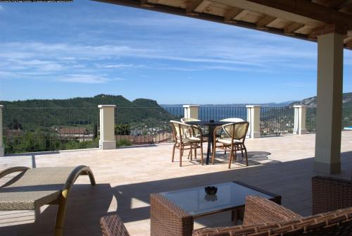 a patio with a table and chairs on a balcony at Villa Benvenuto in Costermano sul Garda