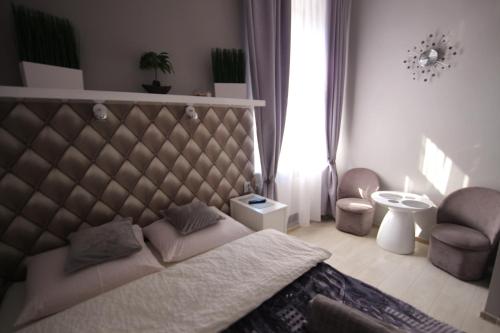a bedroom with a large bed and a chair at Rainbow Apartments 2 in Krakow