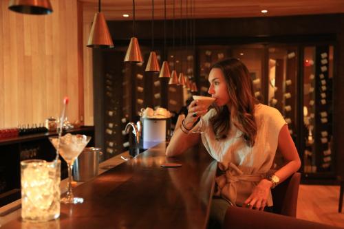 a woman sitting at a table drinking a drink at andBeyond Vira Vira in Pucón