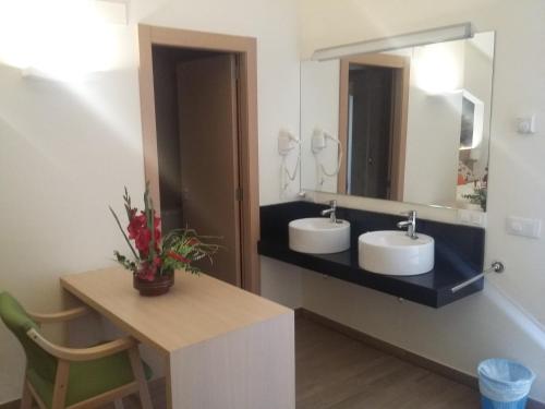 a bathroom with two sinks and a mirror at Hostal Rural San Andrés in Torres del Río