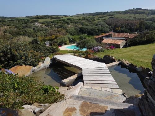 a stone bridge over a pool on top of a hill at La Chintana in Palmadula
