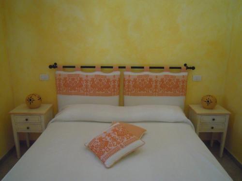 ポルト・サン・パーオロにあるAl mare in Sardegnaのベッドルーム1室(白いベッド1台、ナイトスタンド2台付)