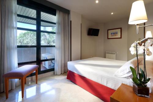 a hotel room with a bed and a window at Exe Gran Hotel Almenar in Las Rozas de Madrid