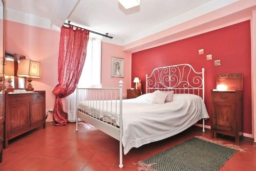 a bedroom with a white bed and a red wall at Apartment Nina in Lucca