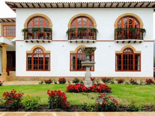 a house with windows and a fountain in the yard at Villa de Los Angeles in Villa de Leyva