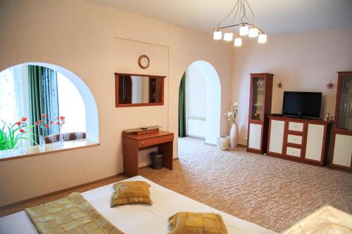 カムイシンにあるGuest house Usadbaのベッド1台と窓2つが備わる広い客室です。