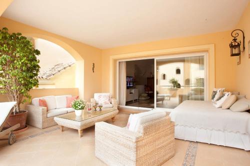 ein Schlafzimmer mit einem Bett und ein Wohnzimmer in der Unterkunft Hacienda Elviria in Marbella