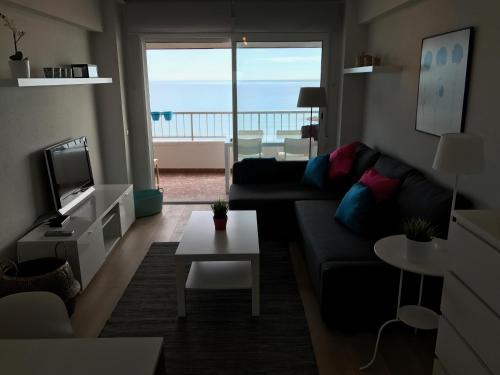 sala de estar con sofá y vistas al océano en Apartments Campello, en El Campello