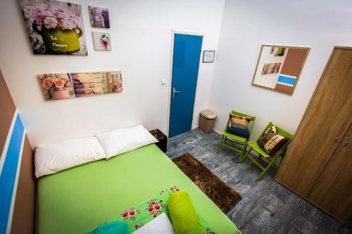 a small room with a green bed and a door at Crazy House Hostel in Pula
