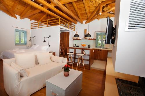 a living room with a white couch and a kitchen at Lithos Guesthouse Kardamili in Kardamili