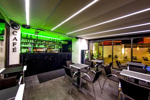 a restaurant with tables and chairs and a bar at Villamar Style Maison in Nazaré