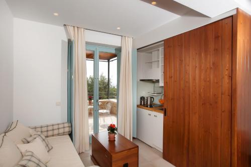 a living room with a couch and a kitchen at Lithos Guesthouse Kardamili in Kardamili
