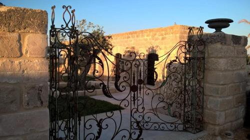 a wrought iron gate with a stone wall at Il Baglio sull'Acqua in Favignana