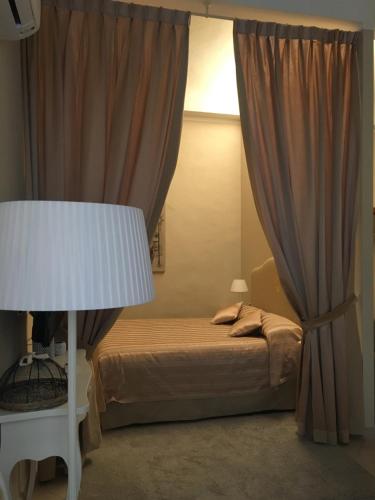 a bedroom with a bed and a white lamp at Residenza Marchesi Pontenani in Florence