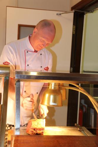 a man in a kitchen preparing a sandwich at Gullane's Hotel in Ballinasloe