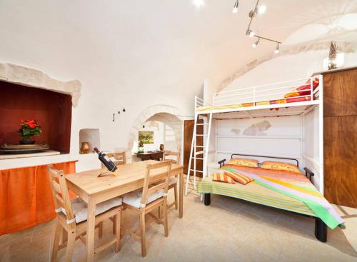 a bedroom with a bunk bed and a wooden table and chairs at Ostunica in Ostuni