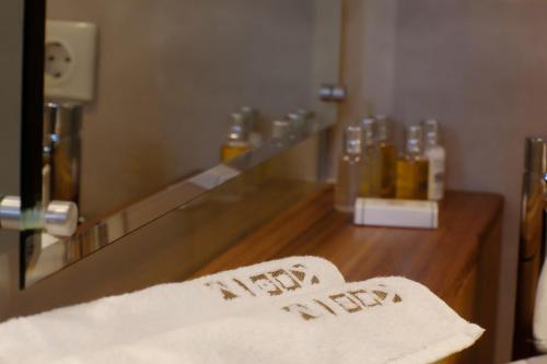 a bathroom with a mirror and towels on a counter at Lithos Guesthouse Kardamili in Kardamili