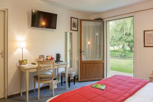 1 dormitorio con escritorio, 1 cama y escritorio en Logis Auberge le petit pont en Tennie