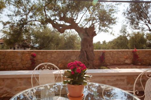 a table with a vase of flowers on top of it at Lithos Guesthouse Kardamili in Kardamili