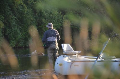 a man is standing in a river holding a fishing line at andBeyond Vira Vira in Pucón