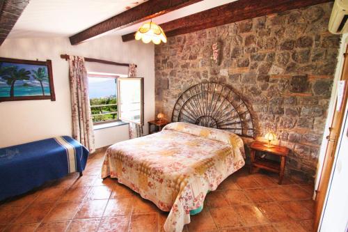 a bedroom with a bed and a stone wall at Agriturismo La Chiana in Vico Equense
