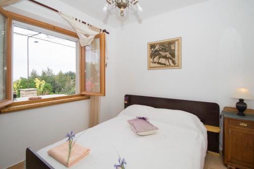 a small bedroom with a bed and a window at Stiniva-stone House in Vela Luka