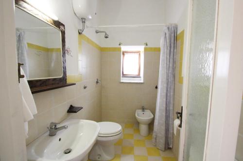Un baño con un inodoro blanco y un lavabo. en Agriturismo La Chiana, en Vico Equense