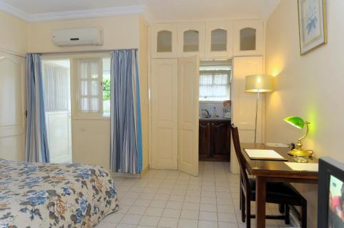 a bedroom with a bed and a desk and a table with a lamp at Residence Eburnea in Abidjan